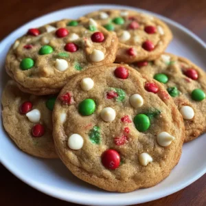Freshly baked, festive cookies with red and green candies on a white plate, perfect for a Christmas Santa cookie recipe.