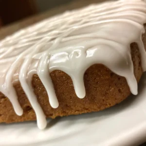 Close-up of a gingerbread loaf cake generously topped with white icing, perfect for a gingerbread icing recipe.