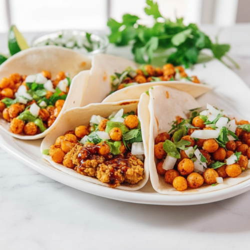 Chickpea Tacos showcasing the Smash & Soy umami technique on a white marble surface with soft natural lighting.