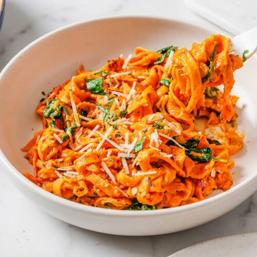Sweet Potato Noodles on a minimalist ceramic plate, showing caramelized edges from the flash-bake method on white marble.