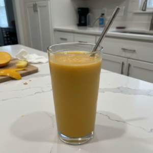 A vibrant yellow McDonalds Mango Pineapple Smoothie Copycat in a tall glass with a straw, garnished with a pineapple wedge.