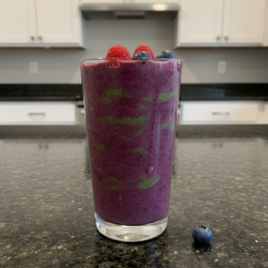 A vibrant, refreshing Spinach Berry Smoothie in a tall glass, garnished with fresh berries and a straw, perfect for a healthy boost.