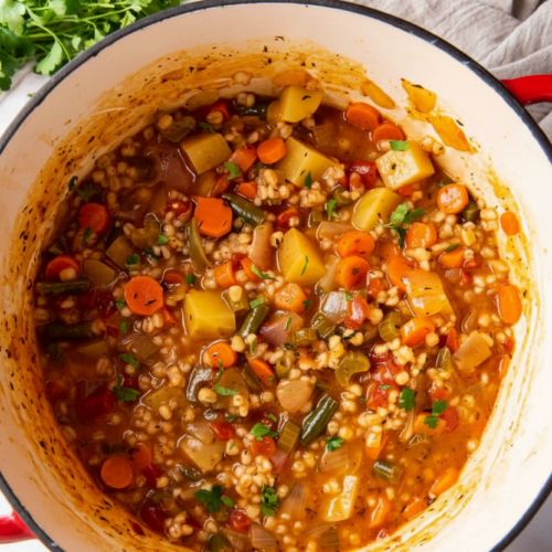 Hearty Vegetable Barley Soup in a minimalist ceramic bowl on a white marble surface with a dark balsamic umami finish.