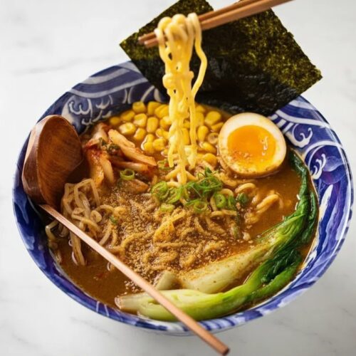 Creamy Vegetarian Ramen in a minimalist ceramic bowl with an umami-rich broth on a white marble surface with soft shadows.