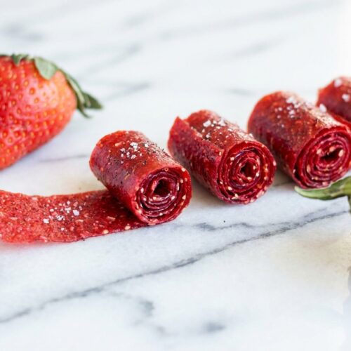 3-Ingredient Strawberry Fruit Roll-Ups with a vanilla twist on a white marble surface in natural window lighting.