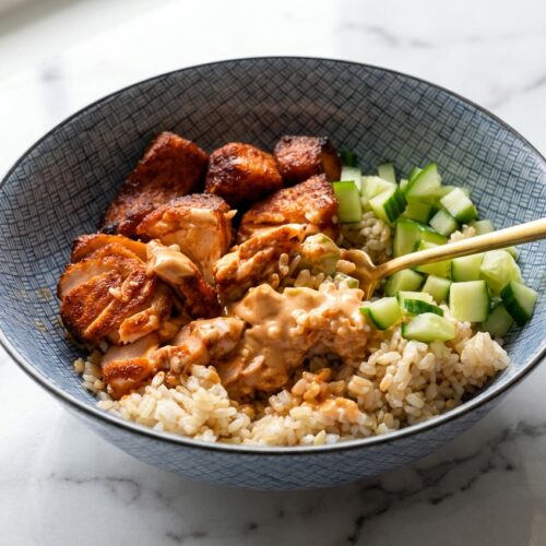Air Fryer Salmon Bites with a savory umami-crust on a minimalist ceramic plate over a white marble surface.