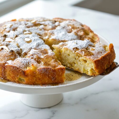 Golden Apple Cake Recipe with brown butter and toasted cardamom infusion on a white marble surface with soft natural lighting.