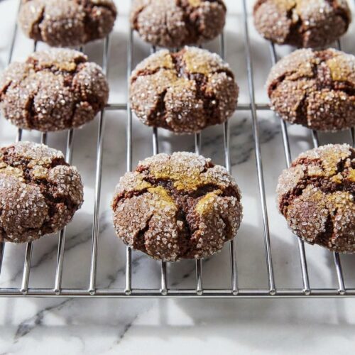 Chocolate Crinkle Cookies with a fudgy center and crackled sugar crust on a white marble surface using the brown butter method.