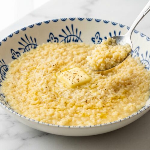 Creamy pastina recipe in a minimalist white bowl on marble, featuring a silky nutmeg and cold butter mantecatura finish.