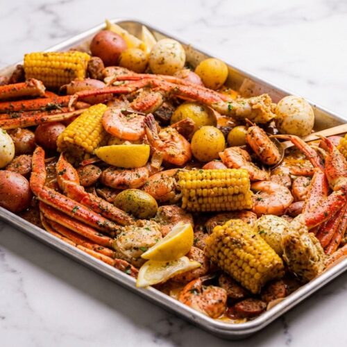 Easy seafood boil recipe featuring flash-charred snow crab clusters and jumbo shrimp on a minimalist ceramic platter.