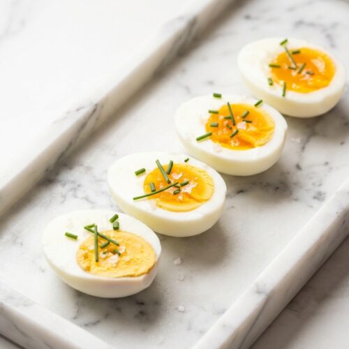 Soft-boiled egg boil recipe with jammy yolks on white marble, featuring the baking soda and vinegar osmosis hack.