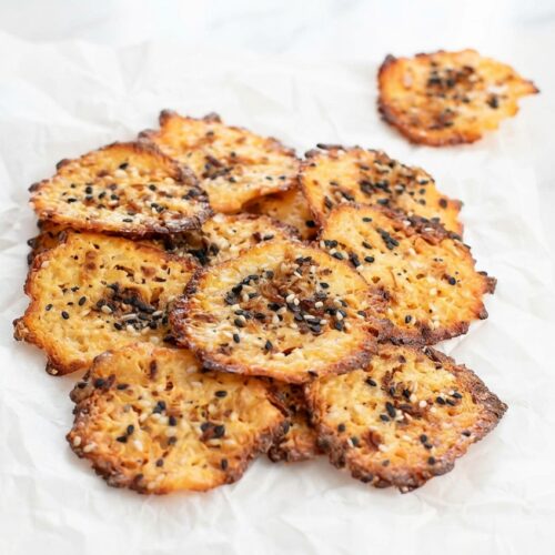 Keto Cottage Cheese Chips with a Parmesan-crusted bottom on a white marble surface under natural window lighting.