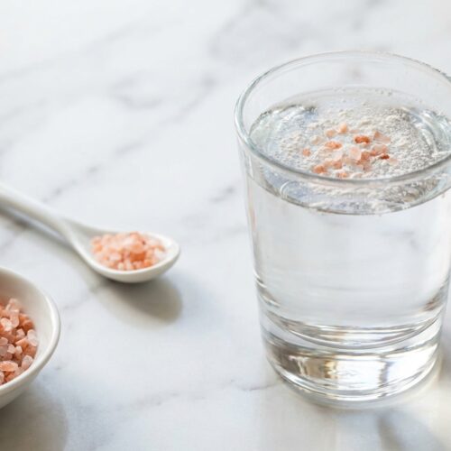 Pink salt diet trick recipe in a minimalist ceramic vessel on a white marble surface with a cream of tartar electrolyte upgrade.
