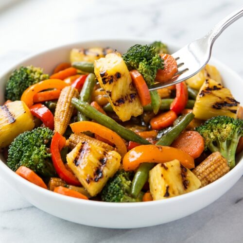 Vegetable Teriyaki Bowl with charred fresh pineapple in a minimalist ceramic vessel on a white marble surface with natural window lighting.