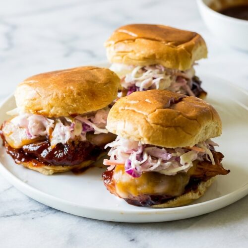 BBQ Chicken Sliders with Smoked Gouda dual-layer cheese barrier on white marble under natural lighting.