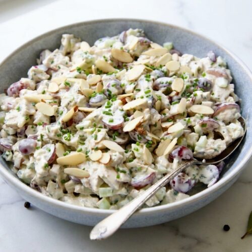 Creamy Chicken Salad With Grapes in a minimalist ceramic bowl on white marble, featuring tender cold-start poached chicken.