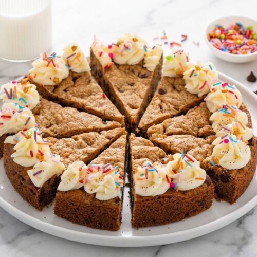 A hero shot of a golden Chocolate Chip Cookie Cake featuring browned butter and espresso powder on a white marble surface.