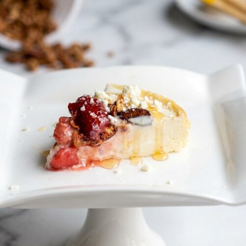 High-angle shot of a Cottage Cheese Cheesecake with a golden Maillard reaction crust and salted honey drizzle on a white marble surface.