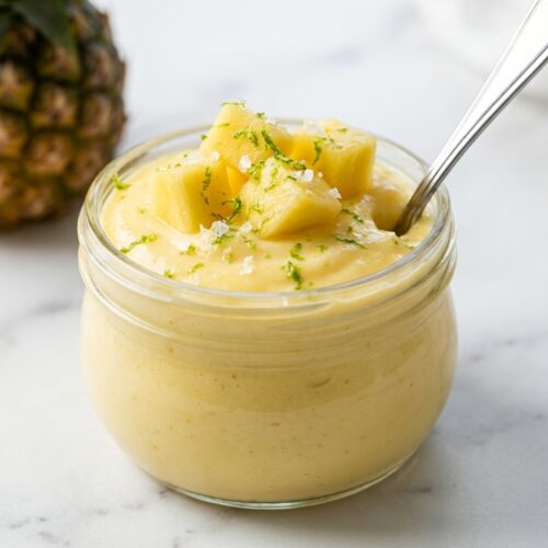 Cottage Cheese Pineapple Mousse Cups in minimalist ceramic vessels on a white marble surface with a lime-zest sea salt finish.