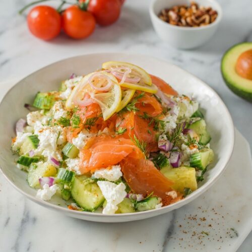 Cottage Cheese Smoked Salmon Salad with flash-pickled lemon shallots in a minimalist ceramic bowl on white marble.