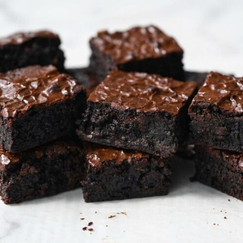 Rich Easy Sourdough Discard Brownies with a double-bloom cocoa crust on white marble under soft natural window lighting.