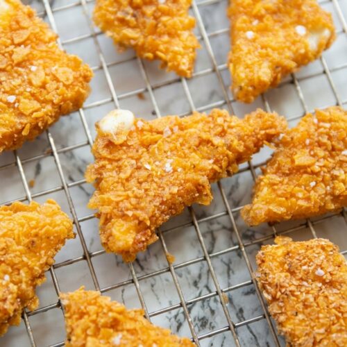 Fried cheese stuffed doritos with a crispy cornstarch shield on a white marble surface under natural window lighting.