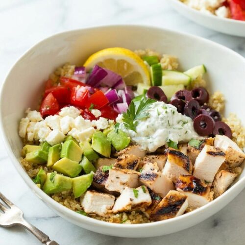 Grilled Chicken Greek Salad With Quinoa & Feta in a minimalist ceramic bowl on white marble, featuring nutty-toasted quinoa.