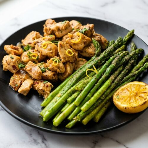 Keto Lemon Garlic Butter Dinner with golden seared chicken and a glossy brown butter lemon emulsion on white marble.