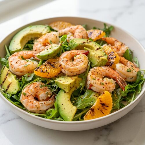 Shrimp & Avocado Citrus Salad with charred mandarin segments and grilled avocado on a white marble surface.