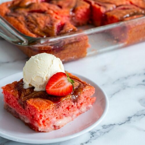 Strawberry Earthquake Cake Recipe featuring a brown butter and macerated strawberry swirl on a white marble surface.