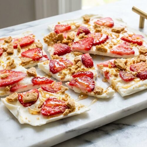 Strawberry Lemon Frozen Yogurt Bark featuring a macerated honey-lemon strawberry swirl on a sleek white marble surface.